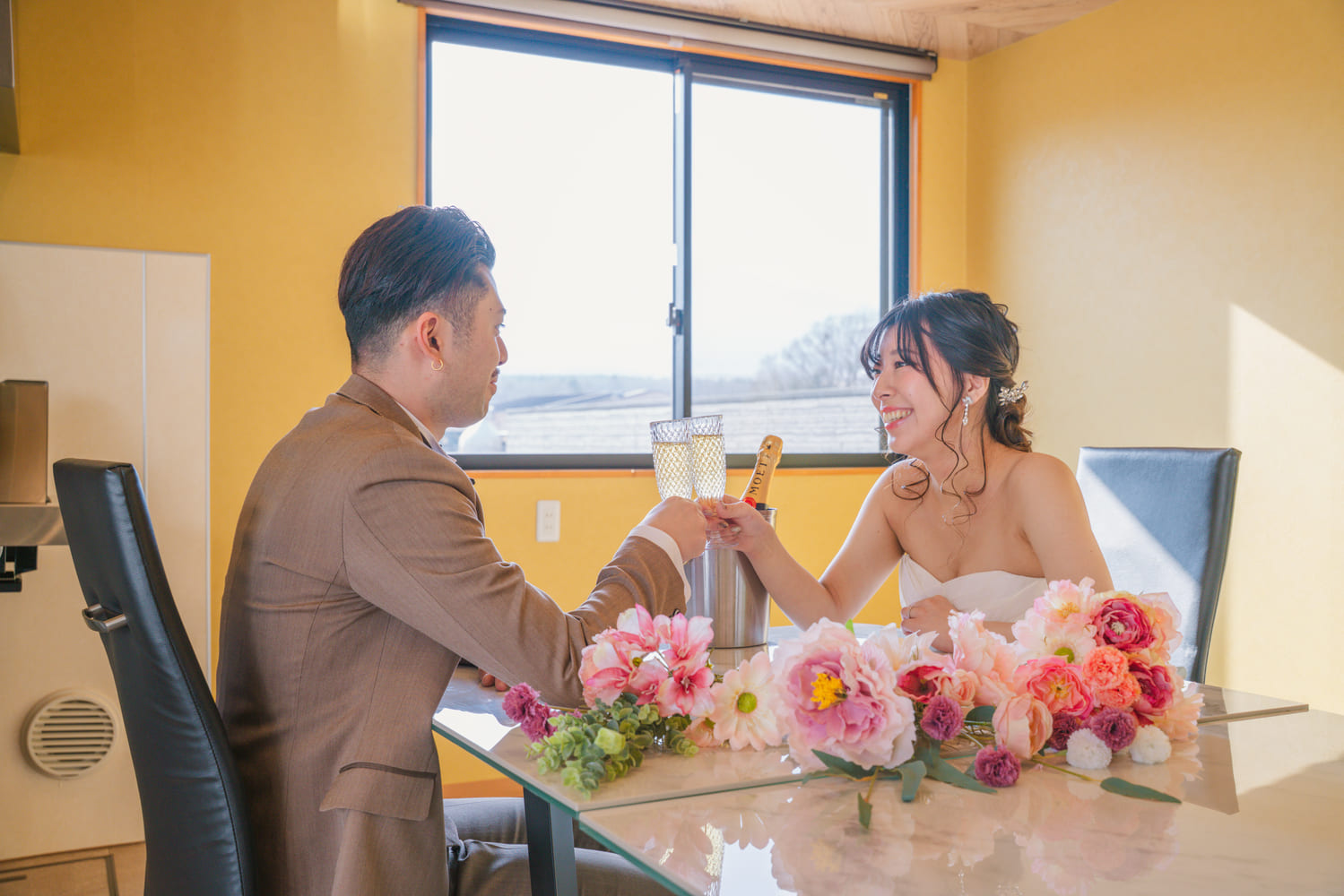 室内でテーブルを囲んでくつろぐ新郎新婦