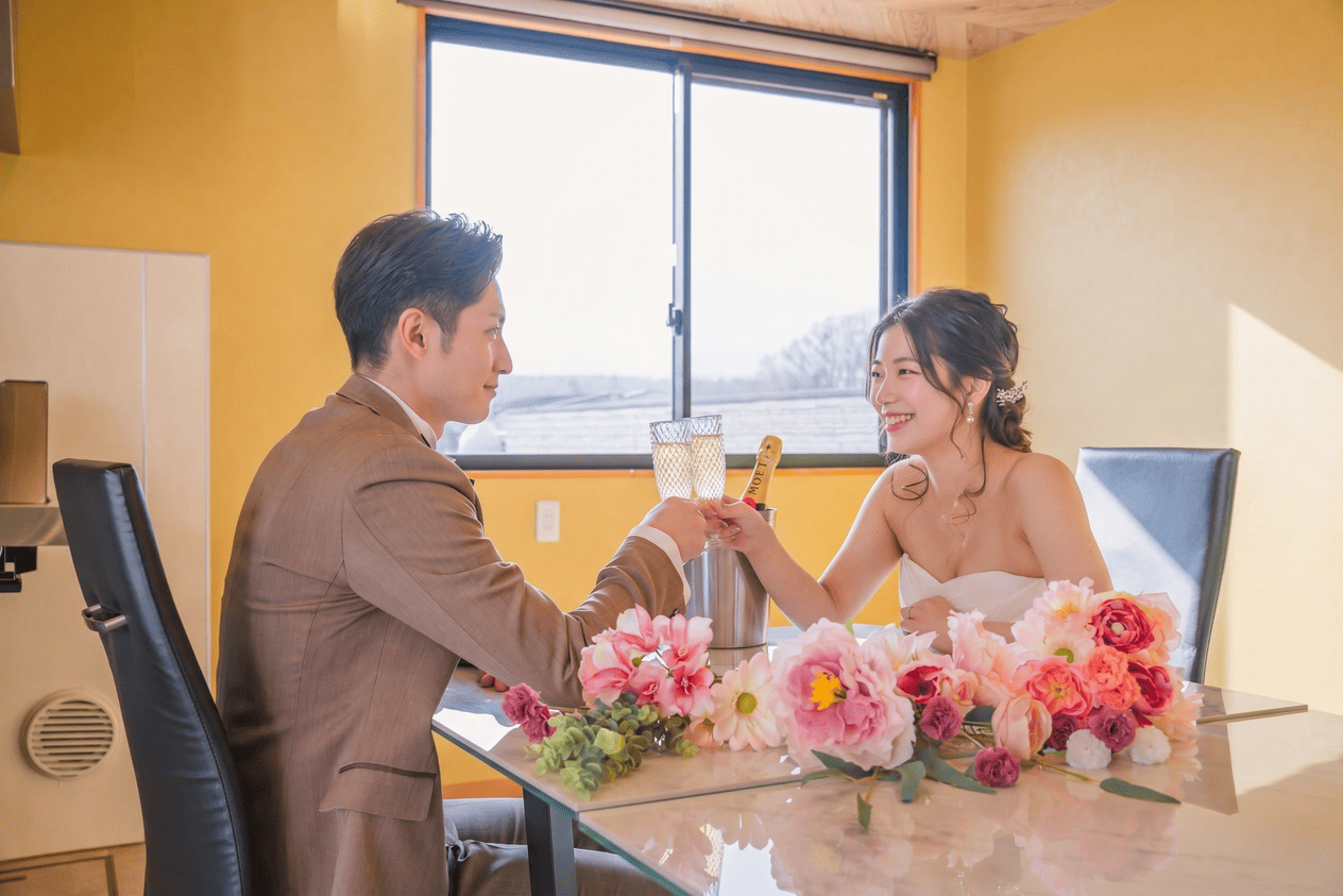 室内でテーブルを囲んでくつろぐ新郎新婦