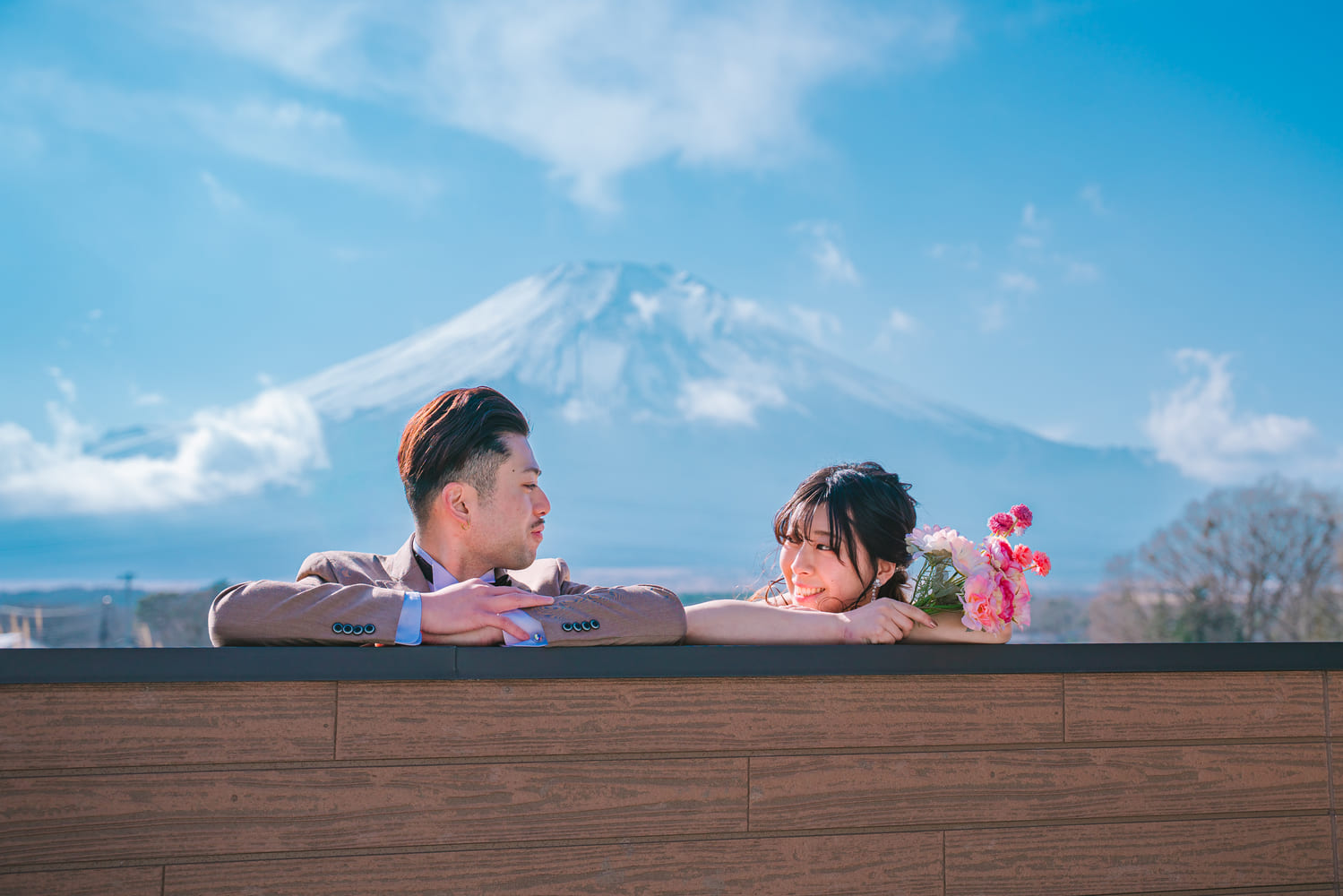 富士山を背景にテラス越しで見つめ合う新郎新婦