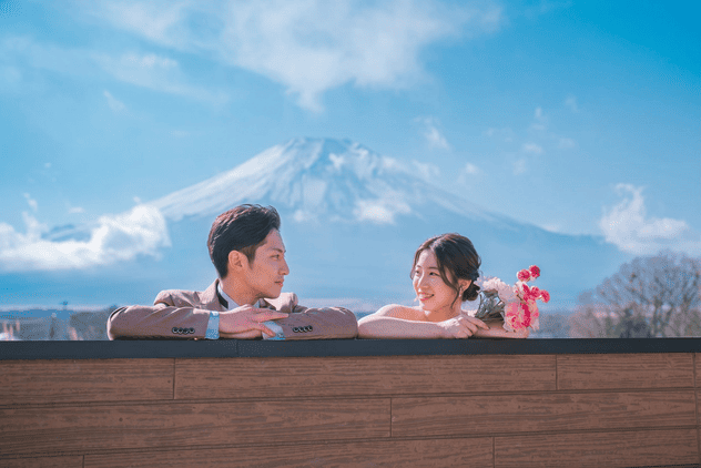 富士山を背景にテラス越しで見つめ合う新郎新婦