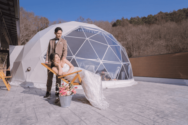 ドームテントの前でくつろぐ新郎新婦
