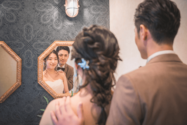 鏡越しに笑顔を見せる新郎新婦