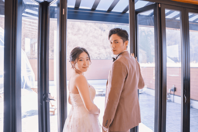 ガラス越しに振り返る新郎新婦